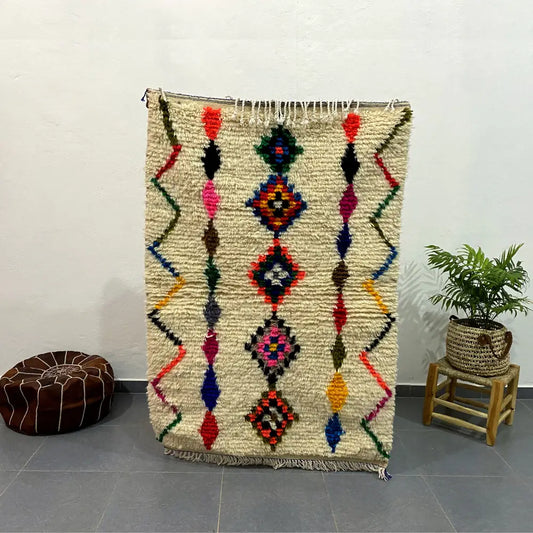 Vibrant cream-colored moroccan handmade azilal rug with geometric diamond and zigzag motifs 1.5m x 1m by DecorBites