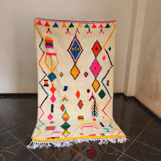 Vibrant cream moroccan handmade azilal rug with colorful diamond triangle motifs and fringed edges 2.5m x 1.5m