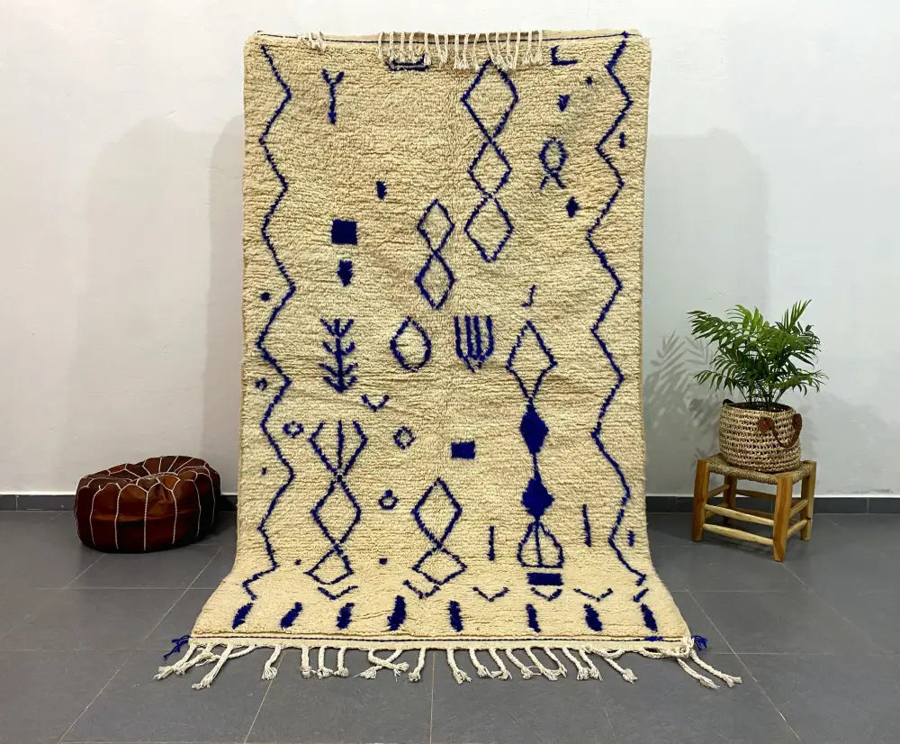 Cream-colored DecorBites™ moroccan handmade azilal rug with intricate blue geometric patterns and fringed edges 2.5m x 1.5m