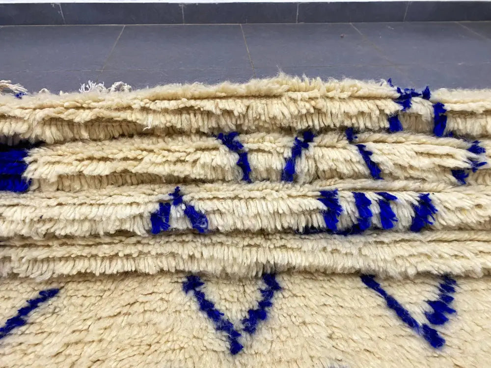 Cream-colored thickly woven moroccan handmade azilal rug with bold blue geometric patterns 2.5m x 1.5m decorbites
