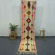 A vibrant cream-colored moroccan handmade azilal rug with bold geometric patterns and textured woolen surface by decorbites