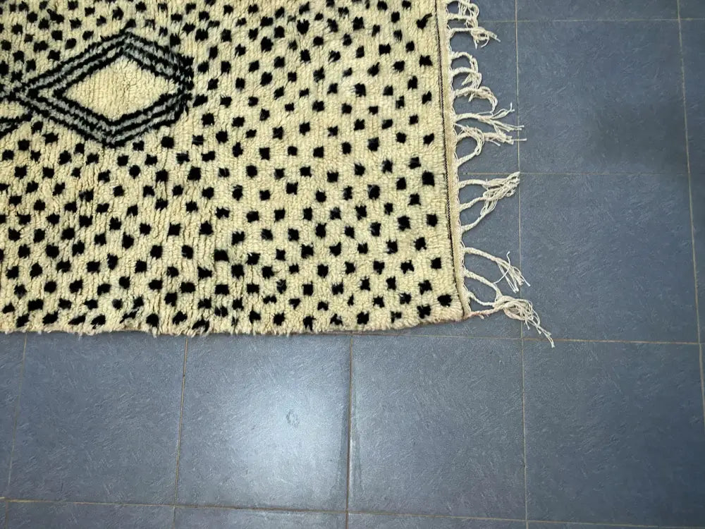 Cream-colored decorbites moroccan handmade azilal rug with black geometric patterns and fringed edges 3m x 2m