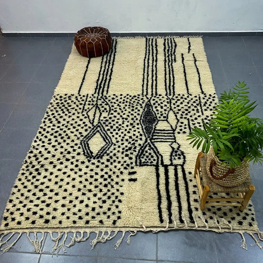 Cream-colored moroccan handmade azilal rug with bold black geometric patterns and fringed edges by decorbites 3m x 2m