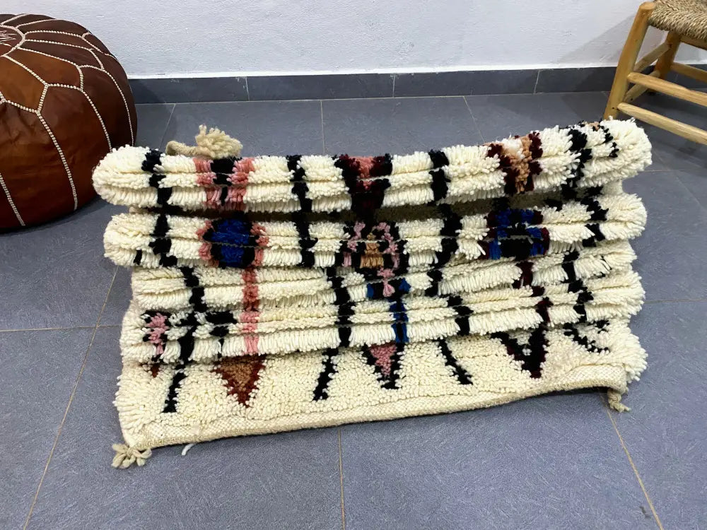Cream-colored chunky-knitted moroccan handmade beni ouarain rug with bold black pink and blue geometric patterns 2.5m x 0.7m