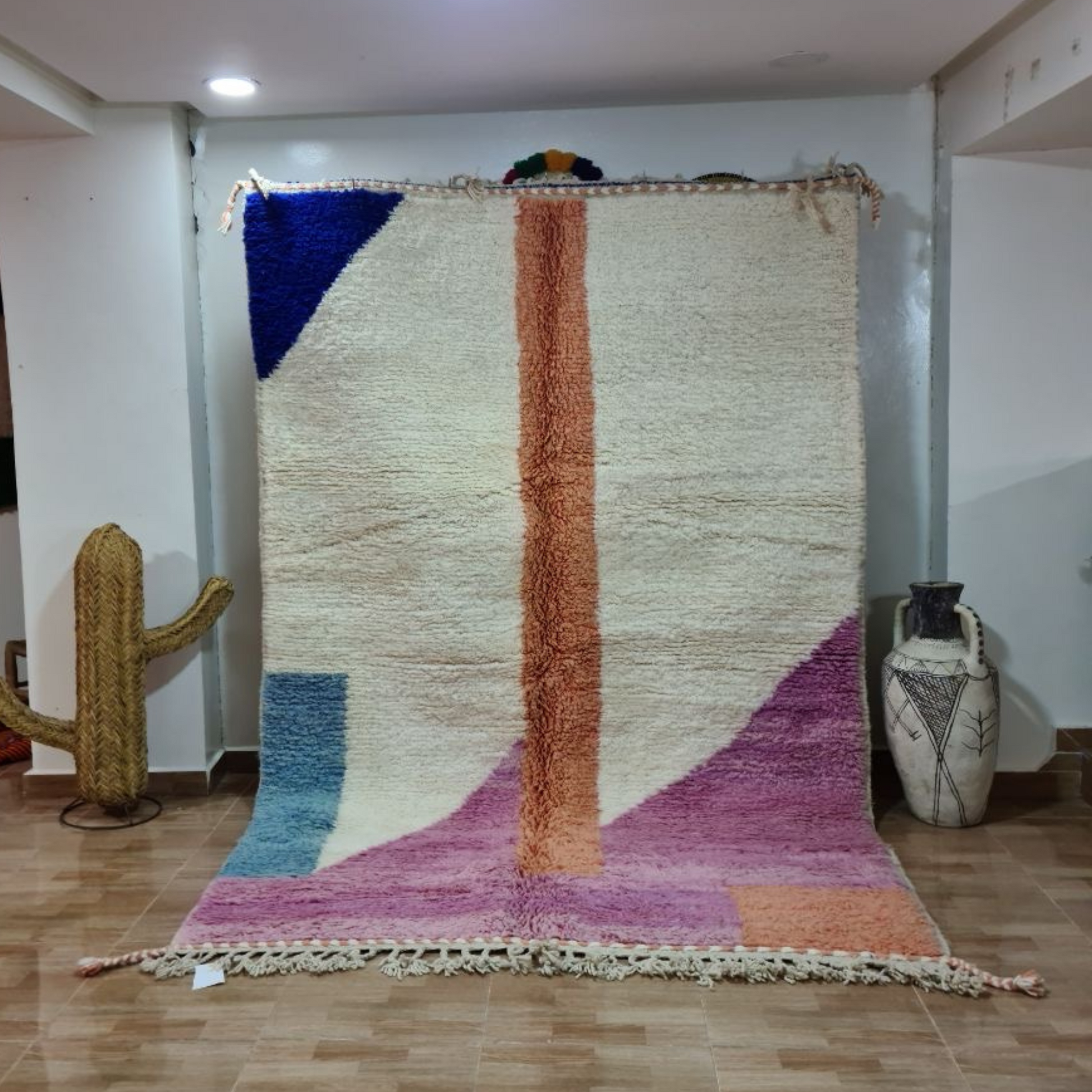 A vibrant moroccan handmade beni ouarain rug with geometric patterns in blue orange purple pink and wool fringed edges