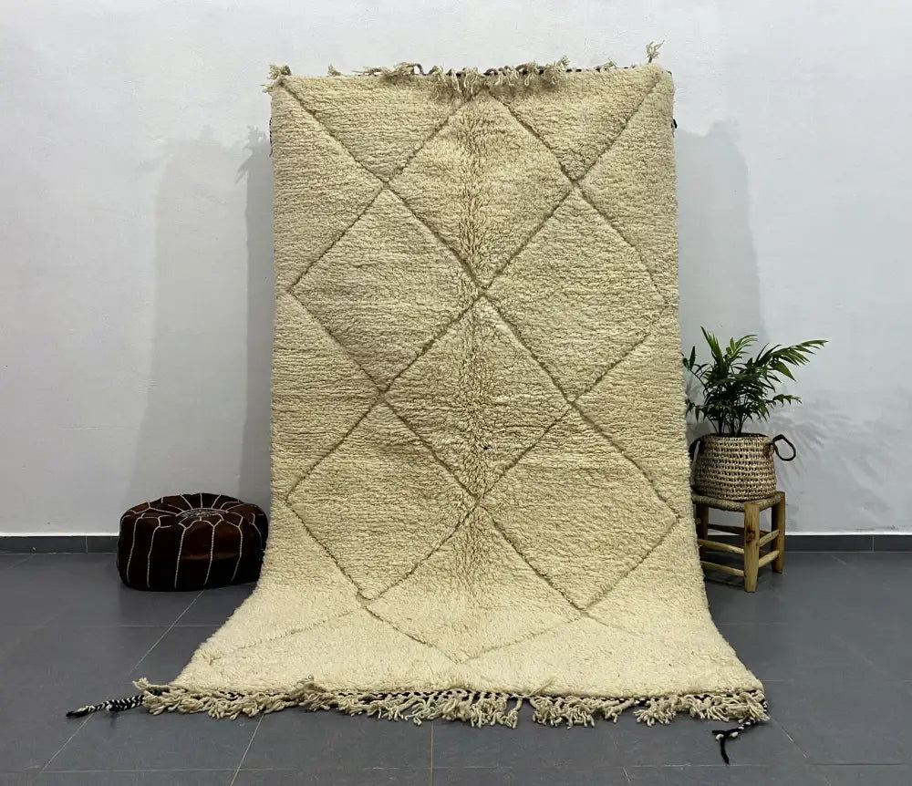 Cream-colored thickly woven moroccan handmade beni ouarain rug with diamond pattern and fringed edges 2.5m x 1.5m