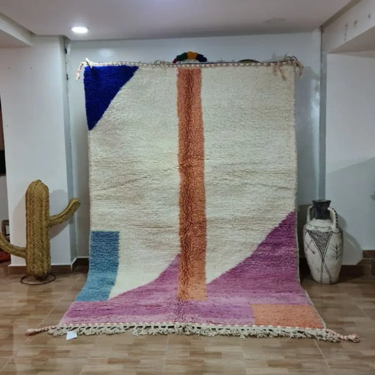 A vibrant moroccan handmade beni ouarain rug with geometric patterns in blue orange purple pink and wool fringed edges