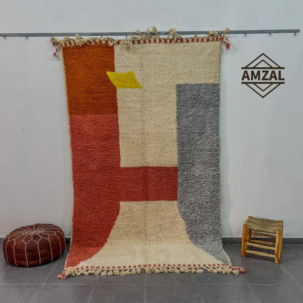 Vibrant geometric wool beni ouarain rug with bold orange, cream, and gray blocks and yellow triangle accent