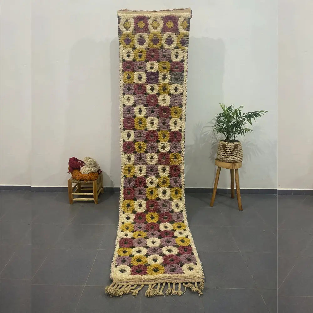 A long moroccan handmade beni ouarain rug with geometric patterns in beige mustard yellow and deep burgundy tones