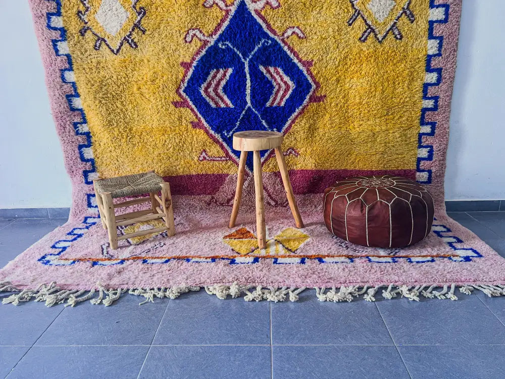 Brown leather moroccan pouf with stitched geometric pattern paired with decorbites™ moroccan handmade beni ouarain rug
