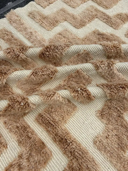 A plush beige and tan chevron-patterned moroccan handmade beni ouarain rug with a textured fuzzy surface 3m x 2m