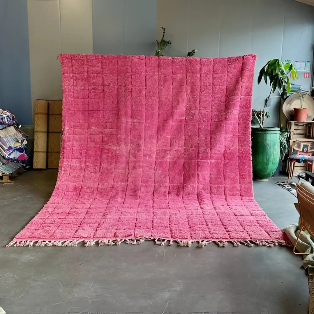 A vibrant fuchsia decorbites moroccan handmade beni ourain rug with textured hand-knotted weave and fringed edges
