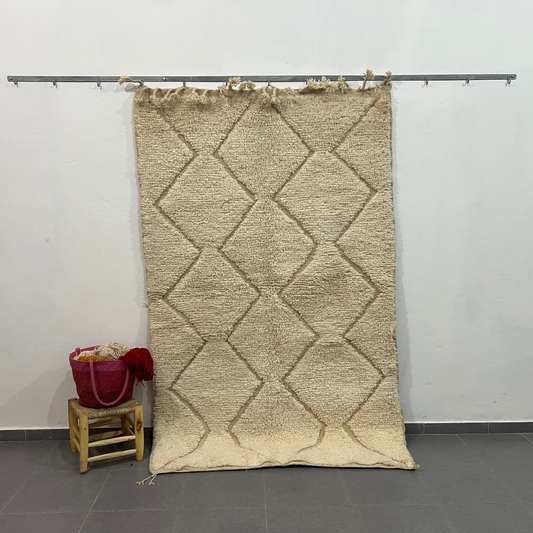 Beige moroccan handmade carpet with textured diamond pattern and fringed edges by skilled artisans for floor covering
