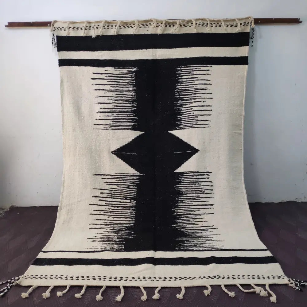 Black and cream-colored moroccan handmade hanbel rug with geometric patterns and tassels by decorbites made to order