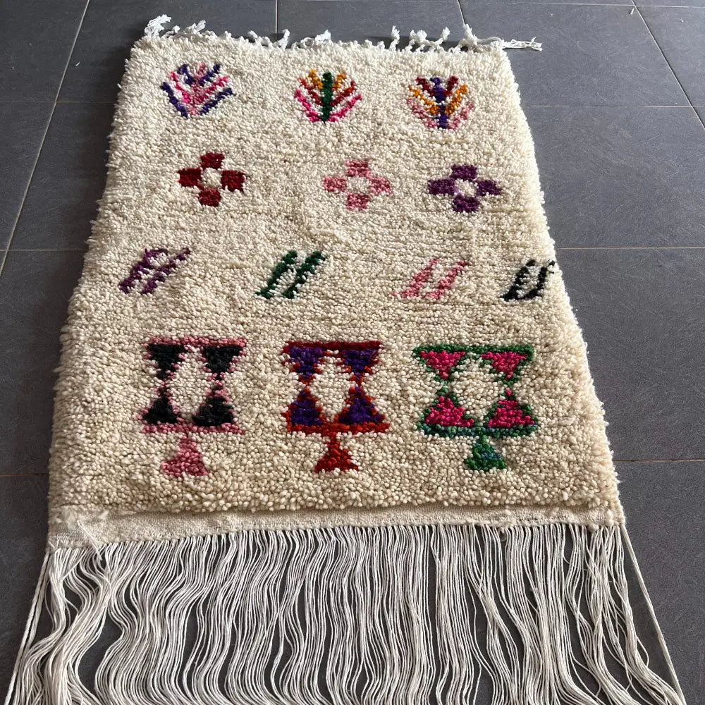 Cream-colored moroccan handmade beni ouarain rug with colorful geometric patterns and fringed edges 1.10m by 80cm