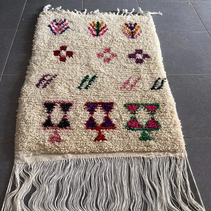 Cream-colored moroccan handmade beni ouarain rug with colorful geometric patterns and fringed edges 1.10m by 80cm