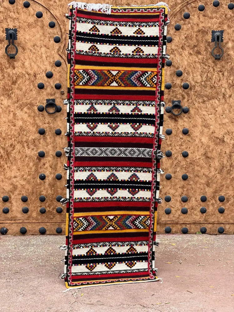 A vibrant moroccan handmade taznakht rug with bold geometric patterns in red black white and mustard yellow 200cm x 60 cm