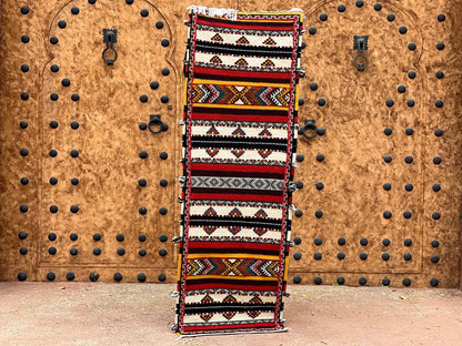 A vibrant moroccan handmade taznakht rug with bold red black white and yellow geometric diamond and zigzag patterns