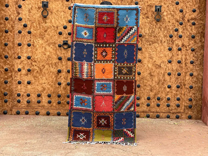 Vibrant moroccan handmade taznakht rug with intricate geometric patterns in bold red blue orange and green tones 200cm x 70cm