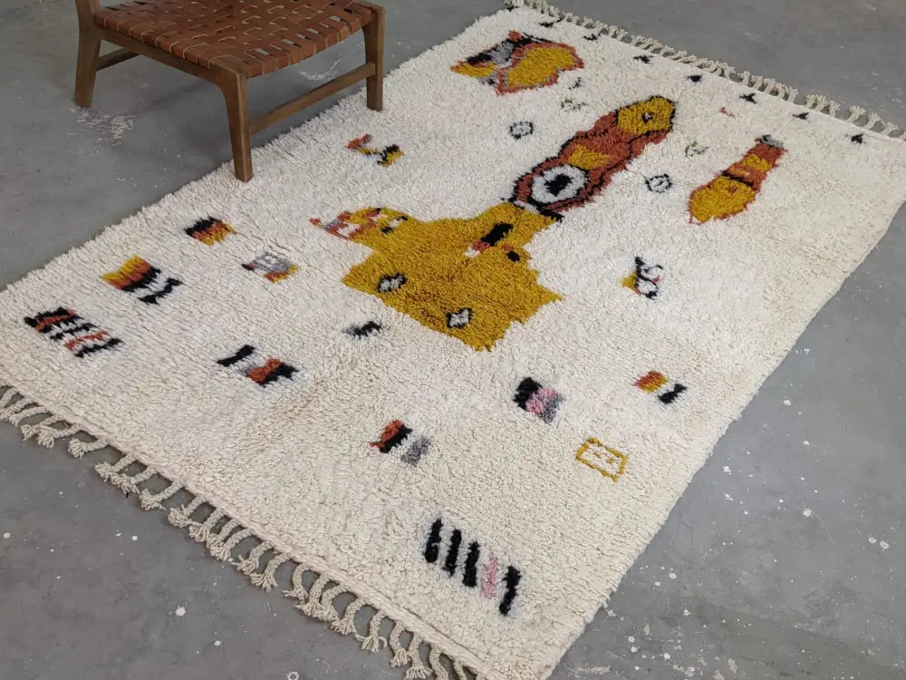 Cream-colored fluffy wool moroccan handmade traditional azilal carpet with yellow and brown abstract patterns on off-white background