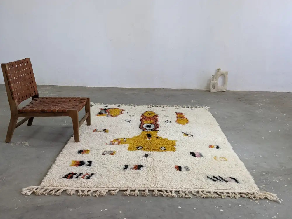 Cream-colored fluffy moroccan handmade traditional azilal carpet with central yellow and black abstract design by decorbites