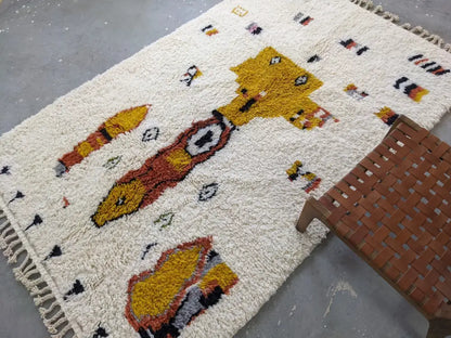 Cream-colored moroccan handmade traditional azilal carpet with fluffy texture and whimsical yellow orange animal pattern