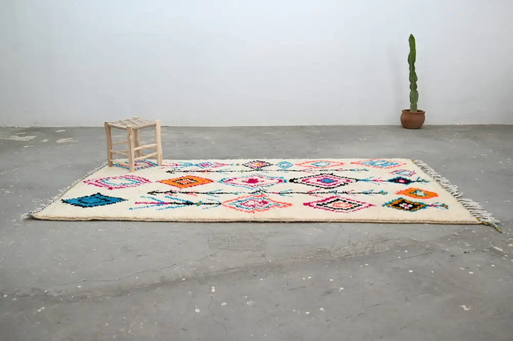 Beige moroccan handmade traditional azilal carpet with colorful pink orange blue and purple geometric patterns 272 x 147 cm