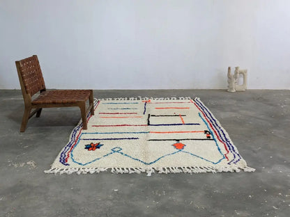 Cream-colored moroccan handmade azilal rug with geometric blue red and orange patterns in pure natural wool 231 x 160 cm