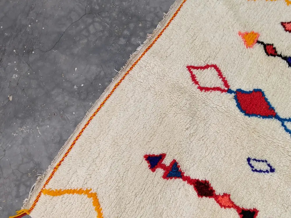 Cream-colored moroccan handmade azilal rug with plush textured surface vibrant geometric patterns pure natural wool