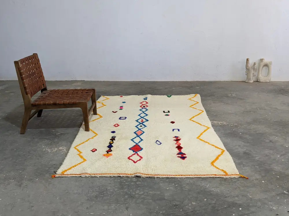 Cream-colored moroccan handmade azilal rug with vibrant geometric patterns in pure natural wool by DecorBites™