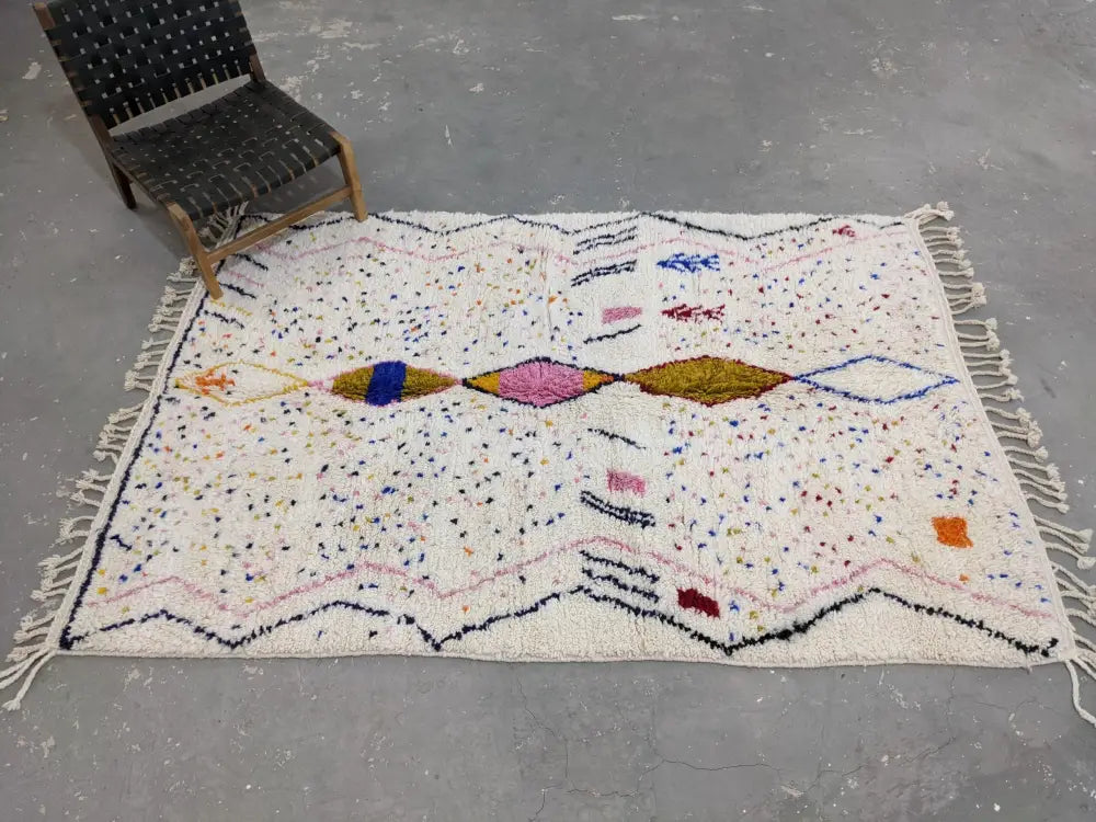 A vibrant moroccan handmade traditional azilal rug with cream base and colorful geometric patterns by DecorBites