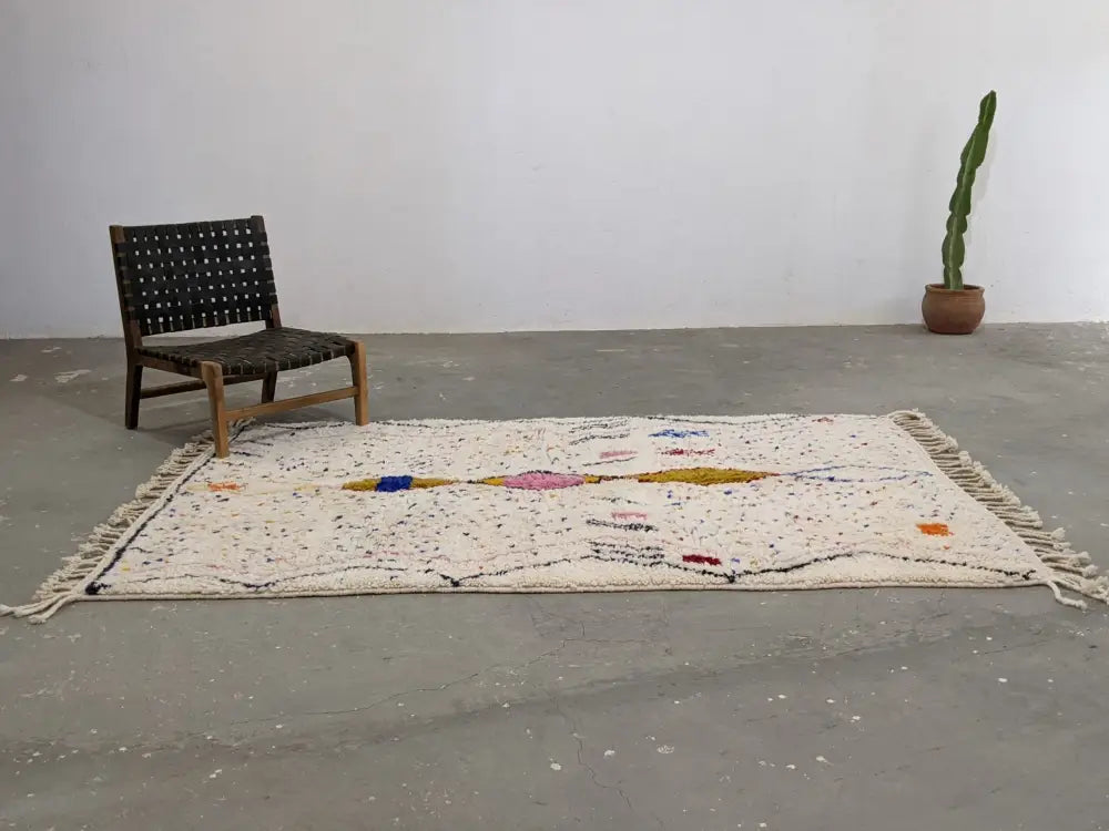Cream-colored DecorBites™ moroccan handmade traditional azilal rug with textured geometric patterns in blue pink yellow and orange