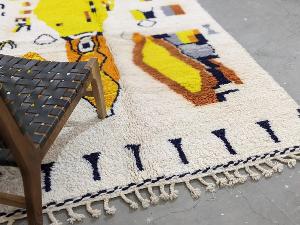 Cream-colored moroccan handmade traditional azilal rug with bold yellow, orange, and navy blue geometric patterns