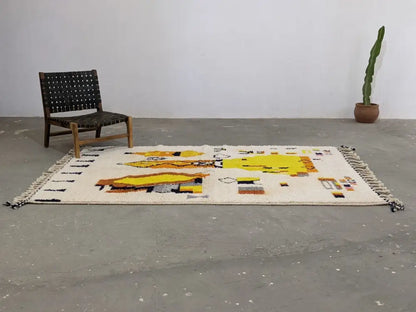 Cream-colored moroccan handmade traditional azilal rug with bold yellow orange geometric patterns and black fringe border