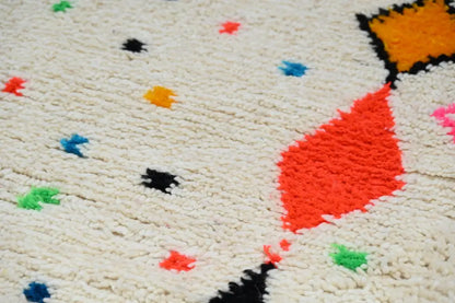 Cream-colored moroccan handmade traditional azilal rug with vibrant orange red black blue and green geometric patterns