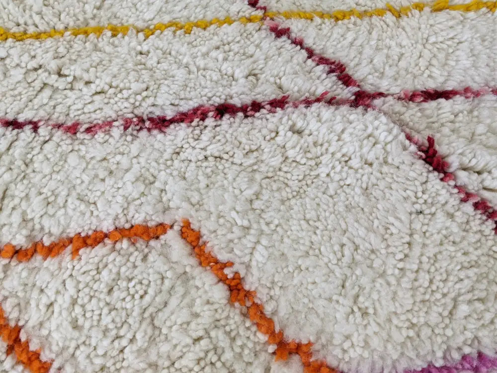 A plush white moroccan handmade traditional azilal rug with vibrant orange red and yellow geometric patterns 252 x 160 cm