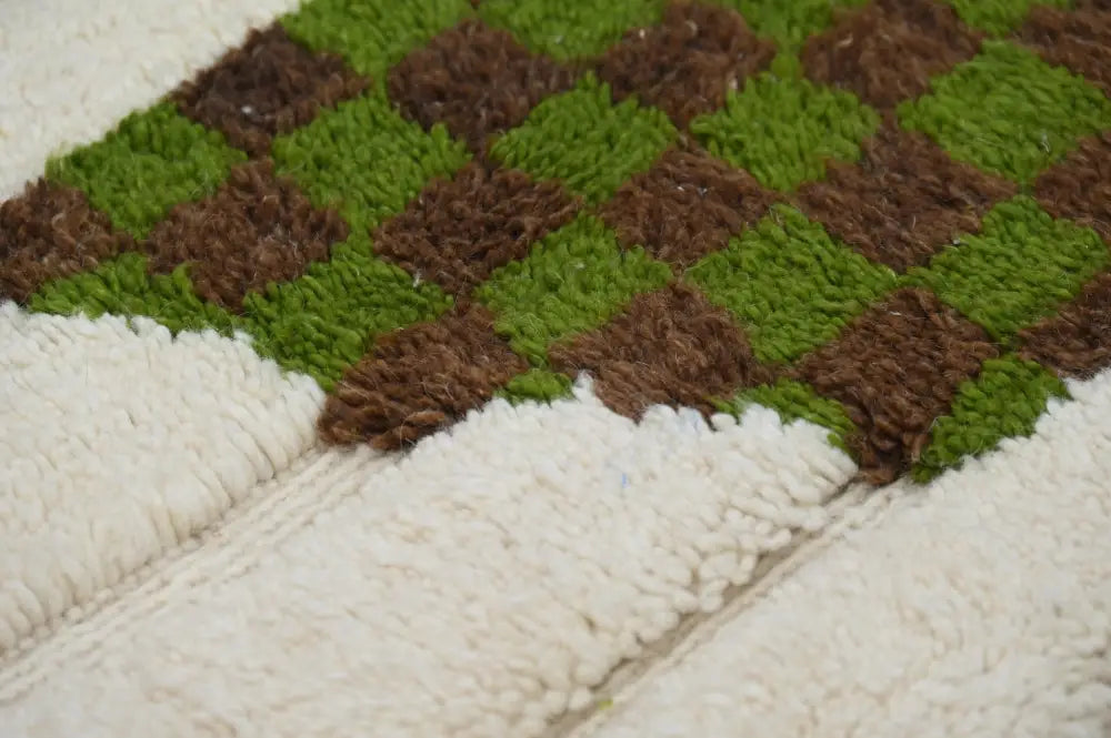 A moroccan handmade traditional azilal rug by decorbites featuring a green and brown checkerboard pattern with white fringe
