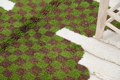 A plush, shaggy moroccan handmade traditional azilal rug with a vibrant green and earthy brown checkerboard pattern