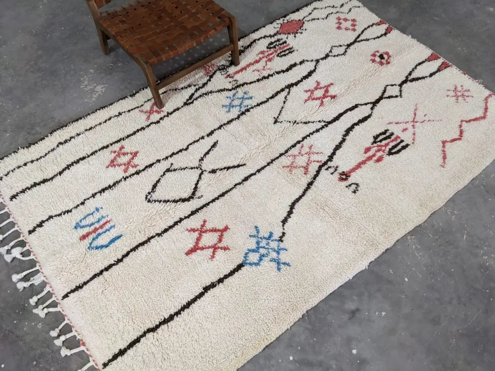 Cream-colored moroccan handmade azilal rug with black red and blue geometric patterns in pure natural wool by decorbites