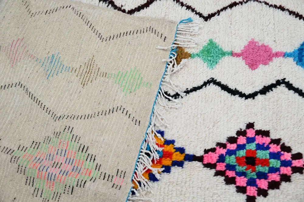 DecorBites™ moroccan handmade traditional azilal rug with cream base and vibrant pink green blue black geometric patterns