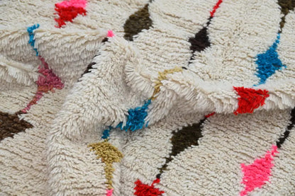 Cream-colored moroccan handmade traditional azilal rug with plush shaggy texture and bold geometric patterns by DecorBites