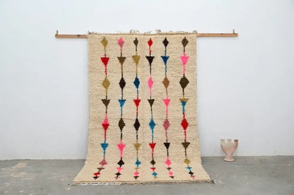 Beige woven moroccan handmade traditional azilal rug with vertical rows of colorful geometric shapes in pink red blue and brown