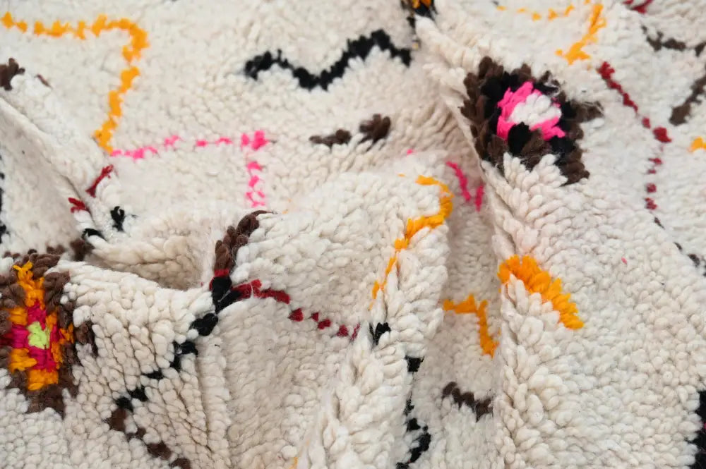 A plush off-white moroccan handmade traditional azilal rug with vibrant pink orange black and brown geometric patterns 258 x 120 cm