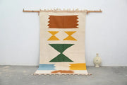 Beige geometric moroccan handmade traditional azilal rug with bold orange yellow green and blue abstract patterns and fringed edges