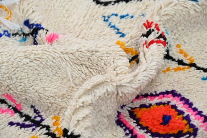 Cream-colored plush wool moroccan handmade traditional azilal rug with vibrant pink orange purple and blue geometric patterns
