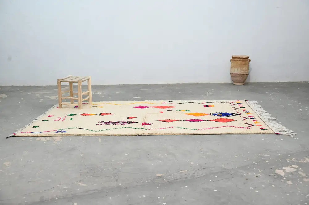 Beige moroccan handmade traditional azilal rug with colorful geometric patterns and fringed edges by decorbites