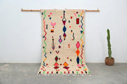 Beige moroccan handmade traditional azilal rug with vibrant geometric patterns in pink blue green orange and red decorbites