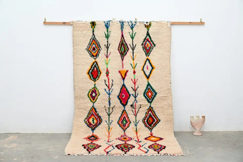Beige moroccan handmade traditional azilal rug with vibrant red green blue and orange geometric patterns by decorbites