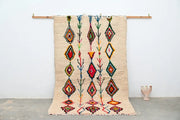 Beige moroccan handmade traditional azilal rug with vibrant red green blue and orange geometric patterns by decorbites