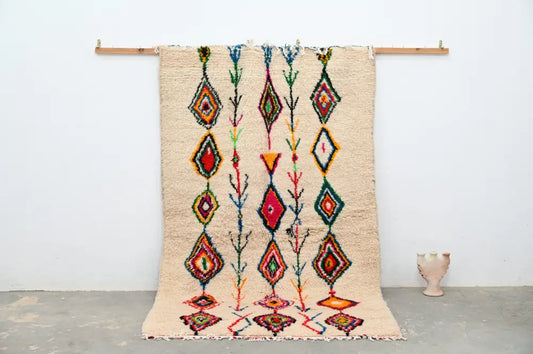 Beige moroccan handmade traditional azilal rug with vibrant red green blue and orange geometric patterns by decorbites